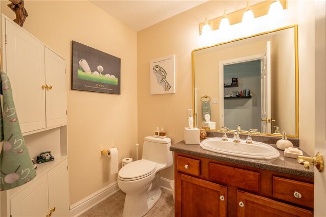 bathroom with vanity, baseboards, tile patterned floors, and toilet