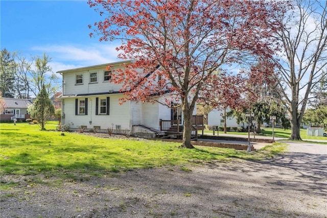 view of front of house with a deck and a front yard