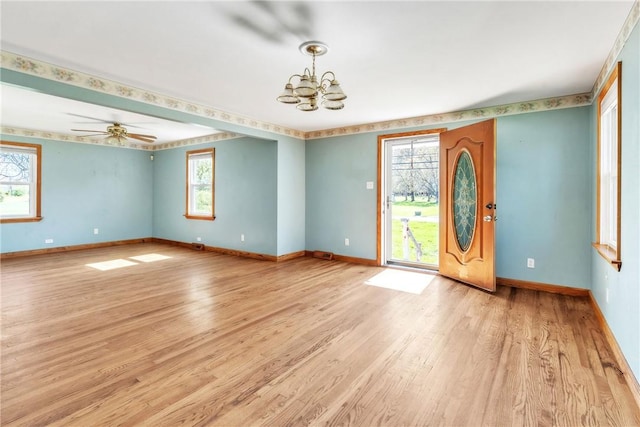 foyer entrance featuring baseboards, light wood finished floors, and a notable chandelier