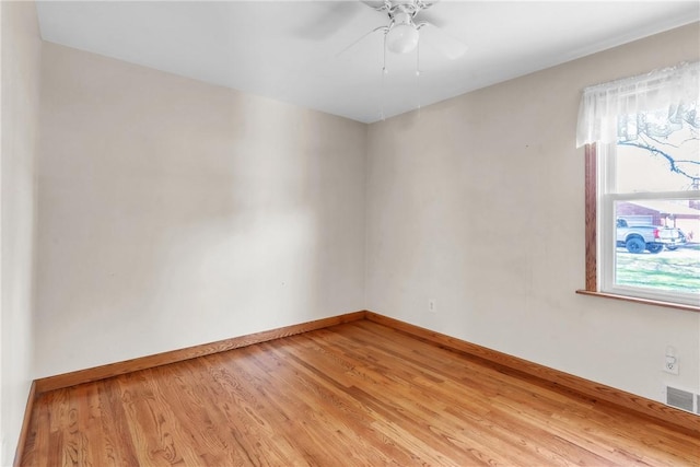 unfurnished room featuring baseboards, a ceiling fan, light wood-style flooring, and visible vents