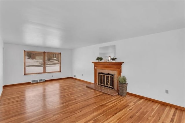 1209 Holy Cross, Monroeville, PA 15146 - unfurnished living room with a glass covered fireplace, baseboards, light wood-type flooring, and visible vents