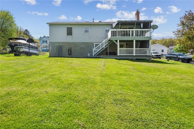 rear view of house with a lawn, a chimney, stairway, and a deck