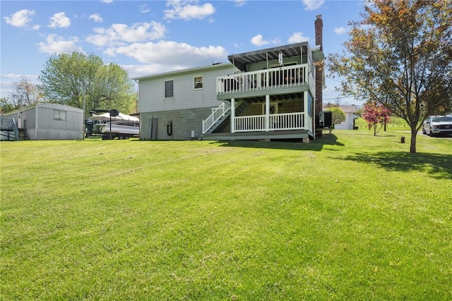 back of property featuring a lawn, stairs, a chimney, and a deck