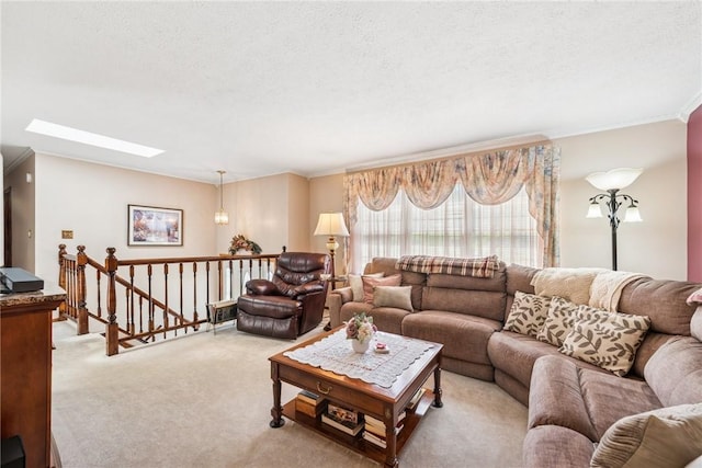 living area featuring crown molding, carpet flooring, a textured ceiling, and a skylight