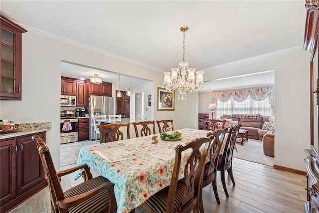 dining room with crown molding, light wood-style floors, baseboards, and a notable chandelier