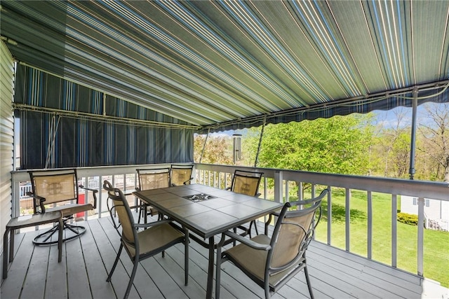 wooden deck with a lawn and outdoor dining space