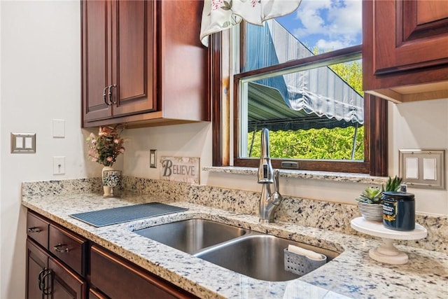 kitchen with light stone counters and a sink