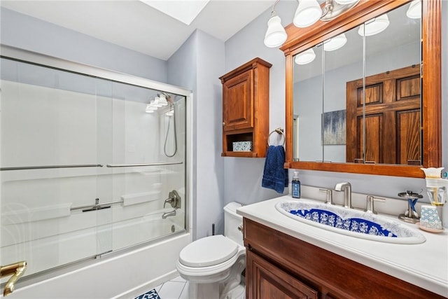 full bathroom featuring vanity, bath / shower combo with glass door, and toilet