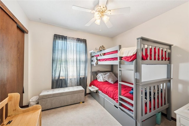 carpeted bedroom featuring ceiling fan and a closet