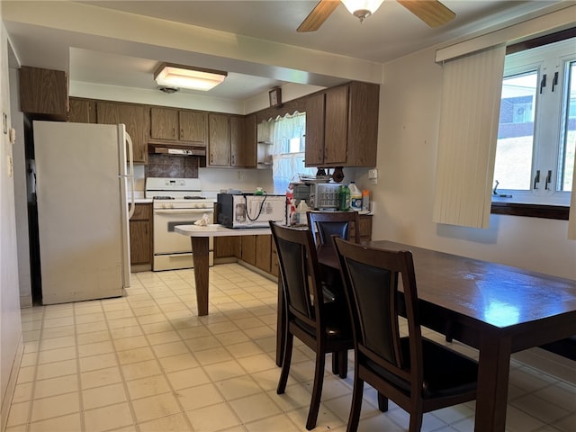 412 Helen Ave, Monessen, PA 15062 - kitchen with dark brown cabinets, white appliances, light countertops, a ceiling fan, and under cabinet range hood