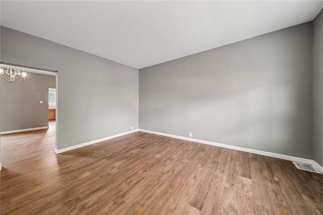 544 4th Ave, New Kensington, PA 15068 - unfurnished room featuring baseboards, wood finished floors, a chandelier, and visible vents