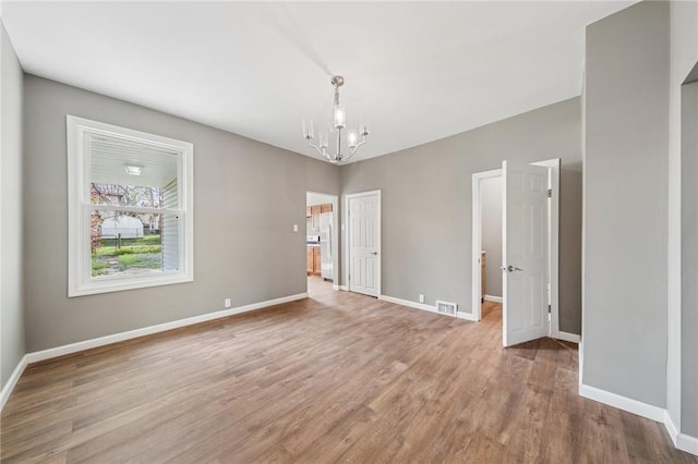 544 4th Ave, New Kensington, PA 15068 - spare room with baseboards, visible vents, wood finished floors, and a chandelier
