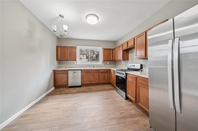 544 4th Ave, New Kensington, PA 15068 - kitchen featuring an inviting chandelier, light countertops, a sink, light wood-style flooring, and appliances with stainless steel finishes