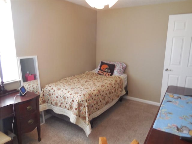 bedroom with baseboards and carpet