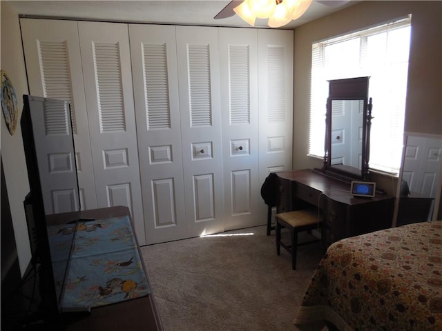 bedroom featuring carpet floors, multiple windows, a ceiling fan, and a closet