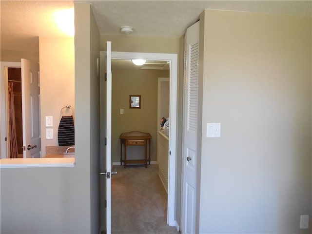 hall with baseboards and carpet flooring