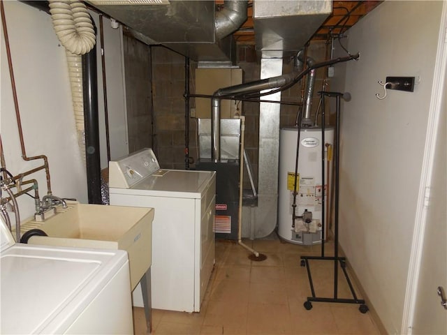laundry room featuring gas water heater, laundry area, light tile patterned flooring, and washer / clothes dryer