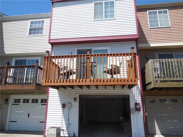 back of property featuring an attached garage and a balcony