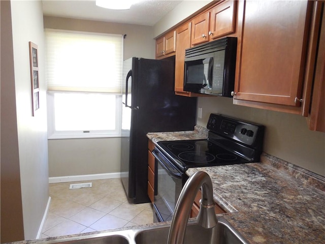 kitchen featuring visible vents, baseboards, plenty of natural light, and black appliances