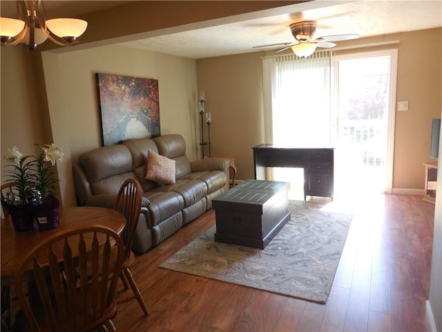 living room with ceiling fan with notable chandelier and wood finished floors