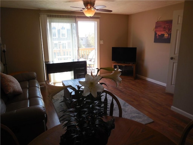 living room featuring baseboards, a ceiling fan, and wood finished floors