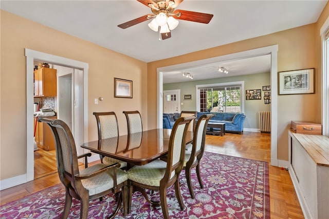 dining area with baseboards, a ceiling fan, and radiator