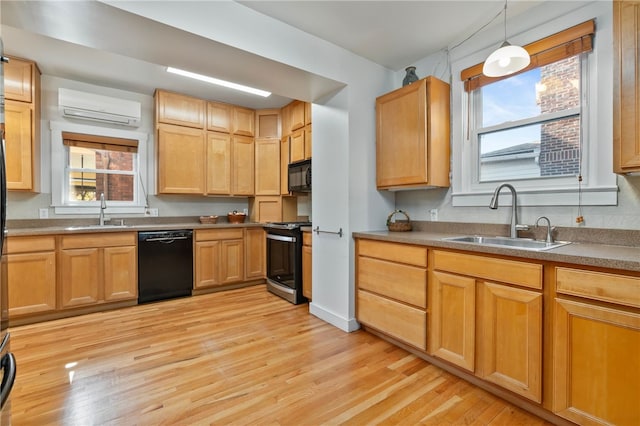 kitchen with light wood-style floors, a wall mounted air conditioner, a sink, and black appliances