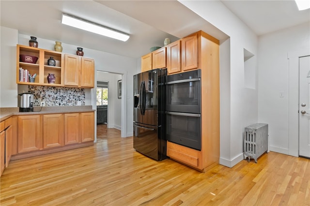 kitchen with open shelves, baseboards, black appliances, light wood finished floors, and radiator