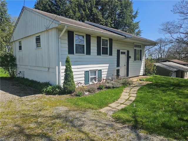 bi-level home featuring board and batten siding and a front yard
