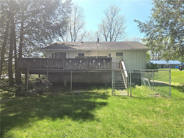rear view of property with fence, a gate, a wooden deck, and a yard