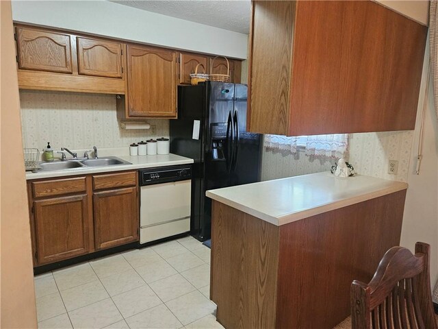 kitchen with black fridge with ice dispenser, white dishwasher, light countertops, brown cabinets, and a sink