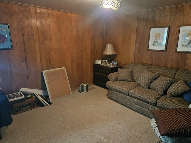 carpeted living room featuring wood walls