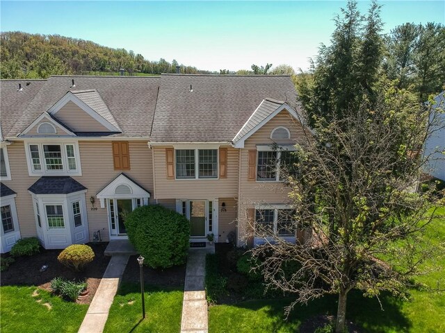 townhome / multi-family property with roof with shingles and central air condition unit