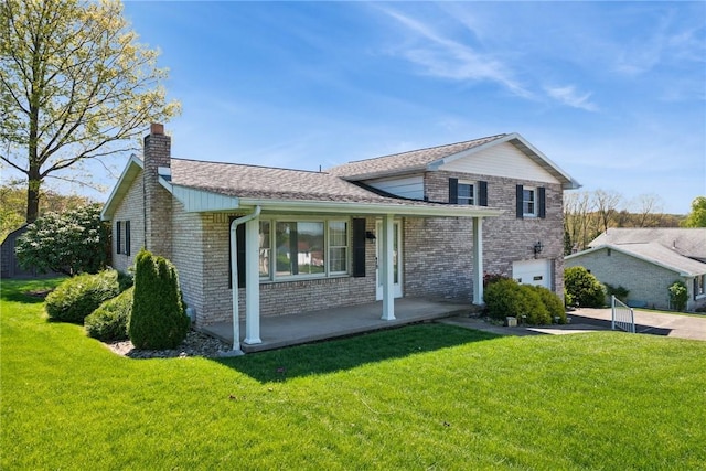 split level home with brick siding, a chimney, and a front lawn
