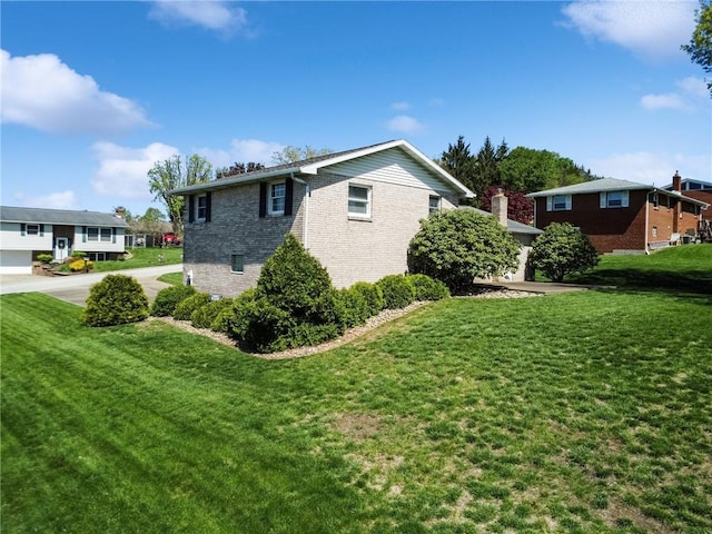 view of side of property with brick siding and a yard