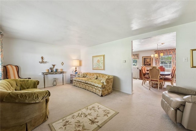 living area with carpet flooring, baseboards, and a chandelier