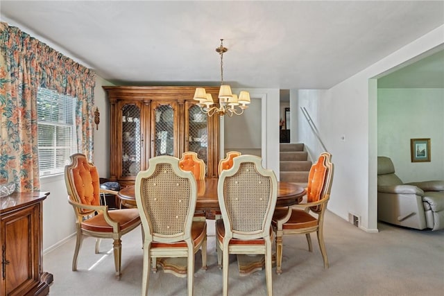 dining area with a notable chandelier, light carpet, baseboards, visible vents, and stairway