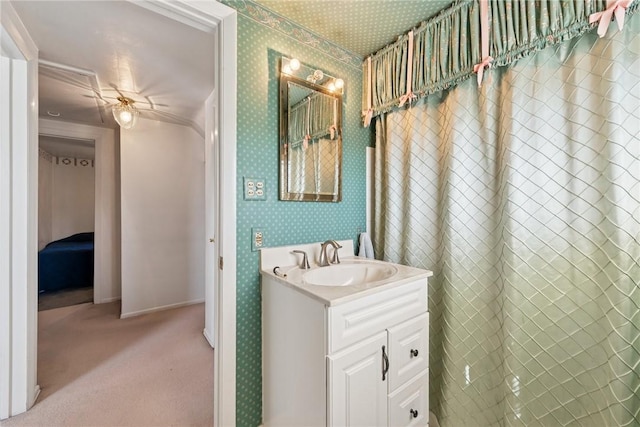 bathroom featuring vanity, baseboards, and wallpapered walls