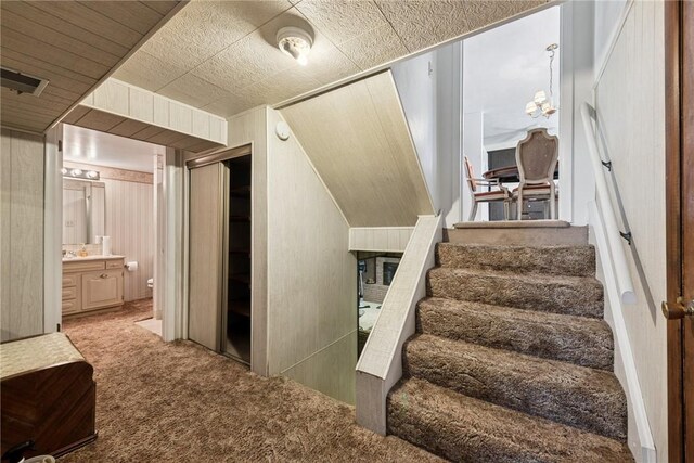 stairway with carpet flooring, a chandelier, and visible vents