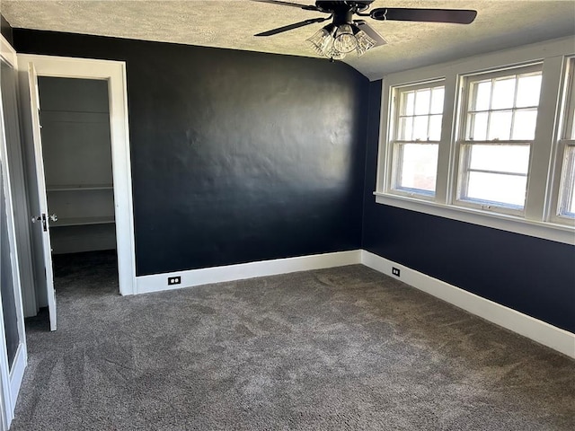 carpeted spare room with a ceiling fan, a textured ceiling, and baseboards