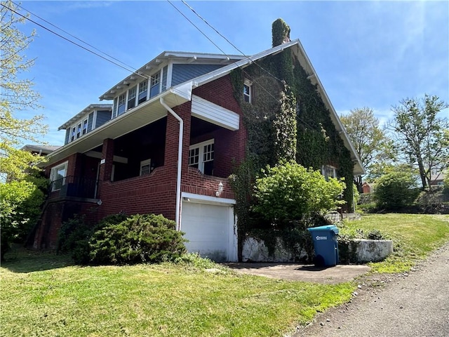 view of home's exterior with brick siding, a garage, a lawn, and driveway