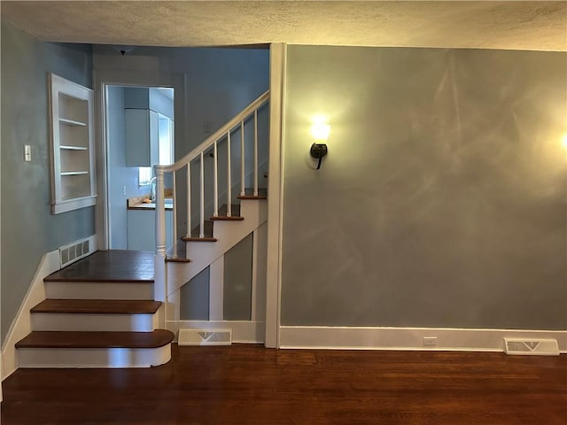 10 Frick Ave, Mount Pleasant Boro, PA 15666 - stairs with visible vents, baseboards, and wood finished floors