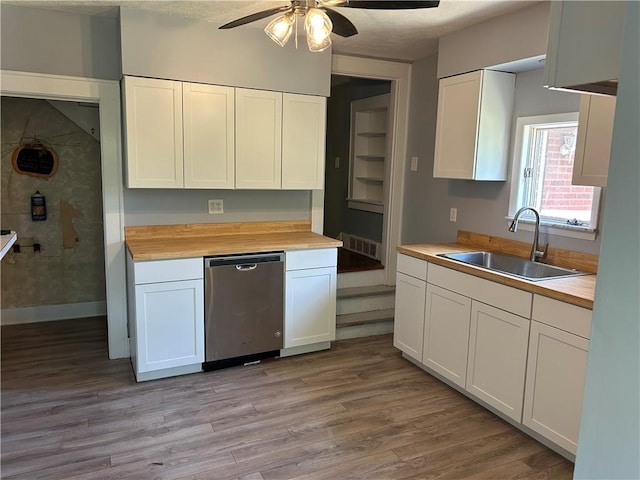 kitchen with a sink, a ceiling fan, white cabinetry, light wood-type flooring, and butcher block counters