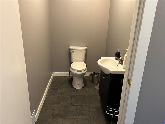 bathroom featuring vanity, baseboards, and toilet