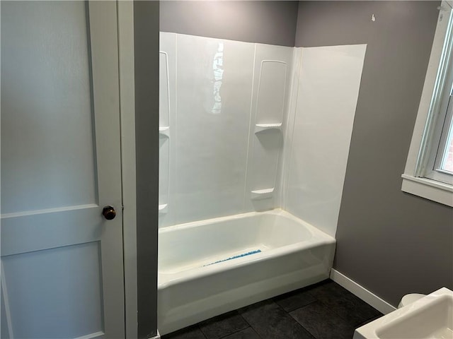 bathroom featuring baseboards and shower / washtub combination