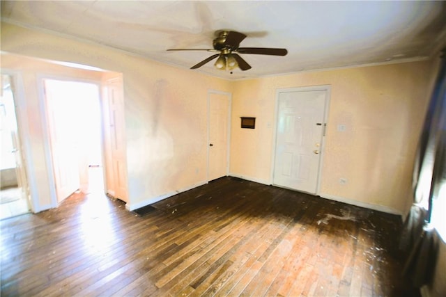 unfurnished room with dark wood-style flooring, a ceiling fan, ornamental molding, and a wealth of natural light