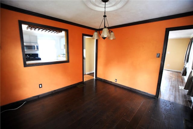 empty room with crown molding, baseboards, and dark wood finished floors