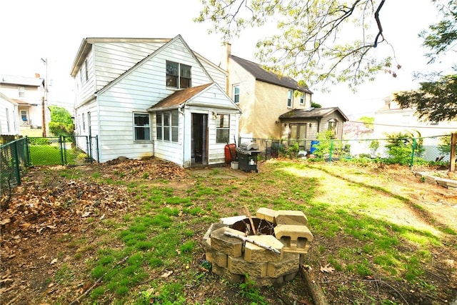 rear view of house with a lawn, a gate, and a fenced backyard