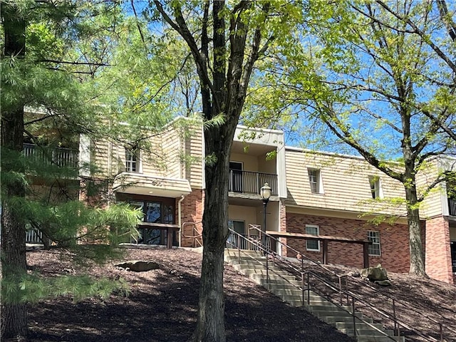 view of side of home with brick siding and a balcony