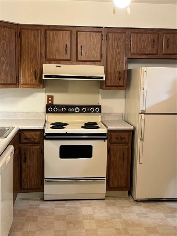 kitchen featuring white appliances, extractor fan, light floors, and light countertops